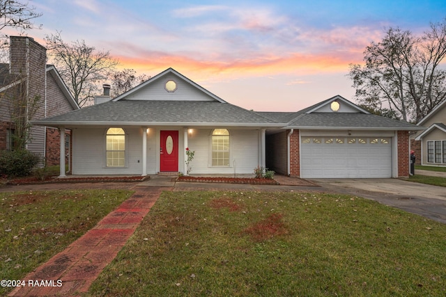 view of front of property with a garage and a yard