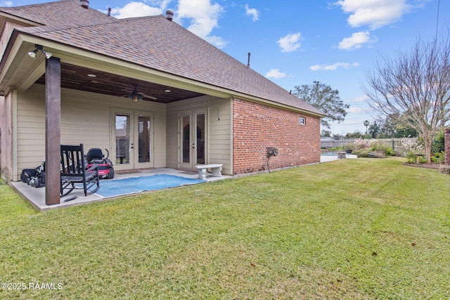 rear view of house featuring a lawn, french doors, brick siding, ceiling fan, and a patio area