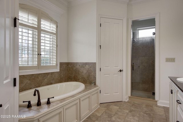 bathroom with a shower stall, vanity, a garden tub, and ornamental molding