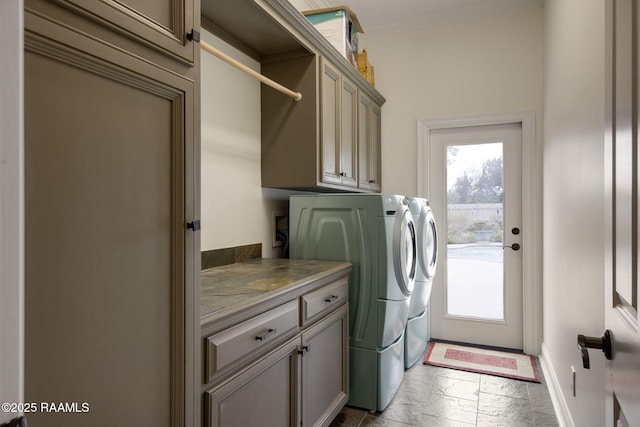 washroom with stone tile floors, baseboards, cabinet space, crown molding, and independent washer and dryer