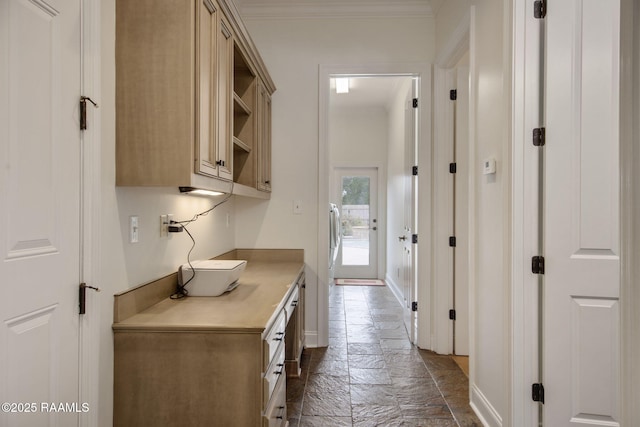 kitchen with baseboards, open shelves, stone tile flooring, light countertops, and crown molding