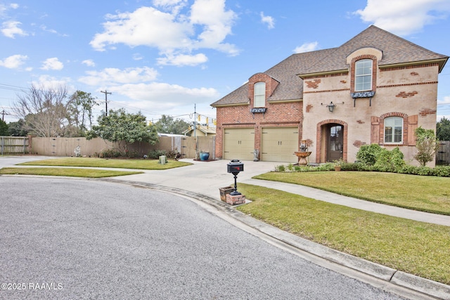 view of front of house with a front lawn, fence, brick siding, and driveway