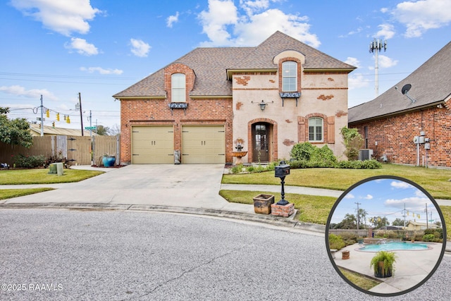 french country style house featuring a front lawn, central AC, fence, concrete driveway, and brick siding