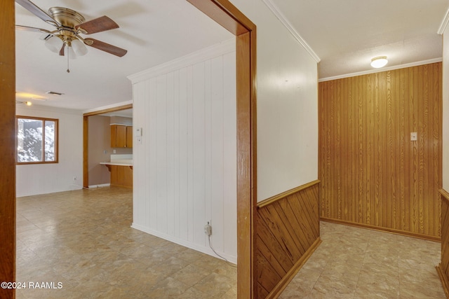 hall featuring crown molding and wooden walls