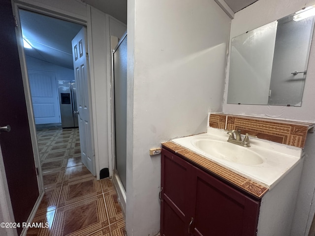 bathroom with decorative backsplash, vanity, and a shower with shower door