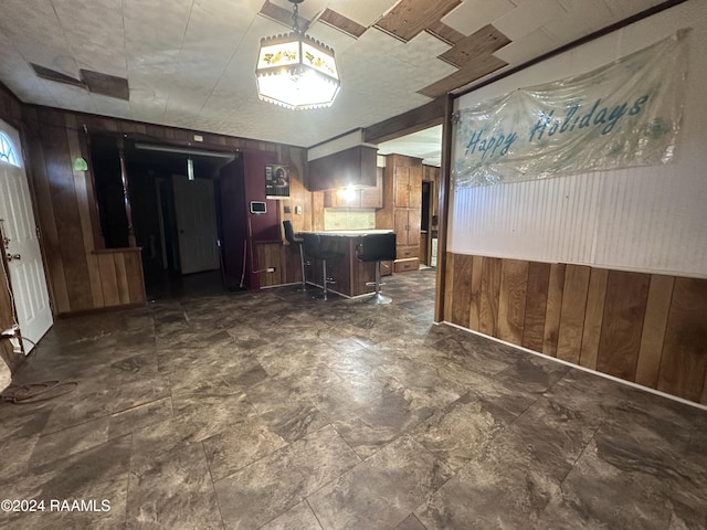 kitchen with a breakfast bar area and wooden walls