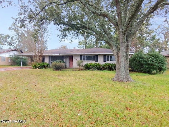 ranch-style house featuring a front lawn and a carport