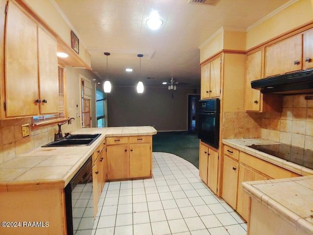 kitchen featuring tasteful backsplash, a peninsula, under cabinet range hood, black appliances, and a sink