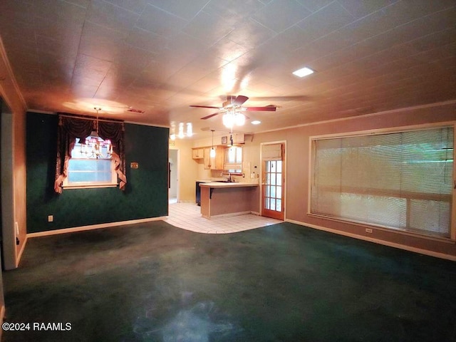 unfurnished living room with carpet flooring, ceiling fan, and baseboards