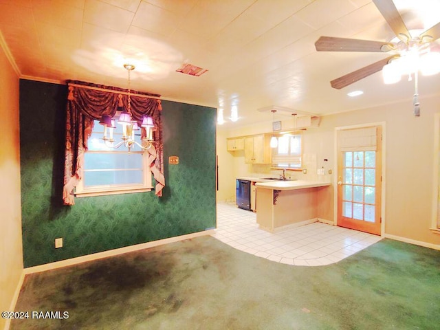 kitchen featuring decorative light fixtures, light colored carpet, and black dishwasher