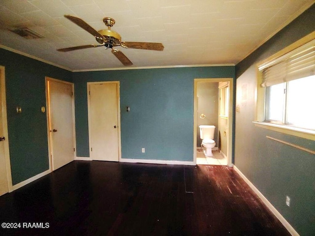 unfurnished bedroom with connected bathroom, wood finished floors, visible vents, baseboards, and ornamental molding