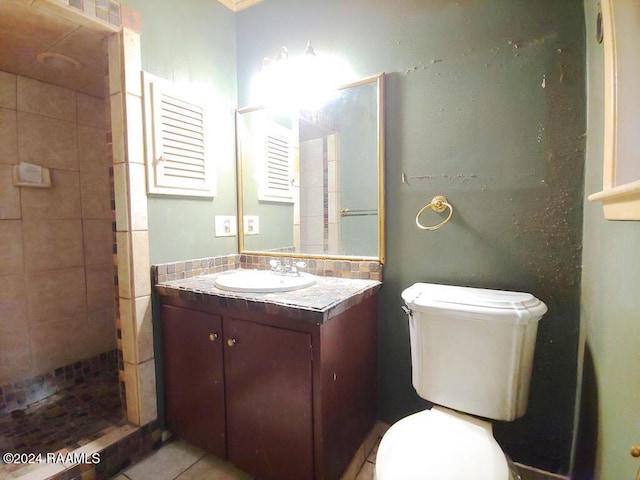 full bath featuring a tile shower, vanity, toilet, and tile patterned floors