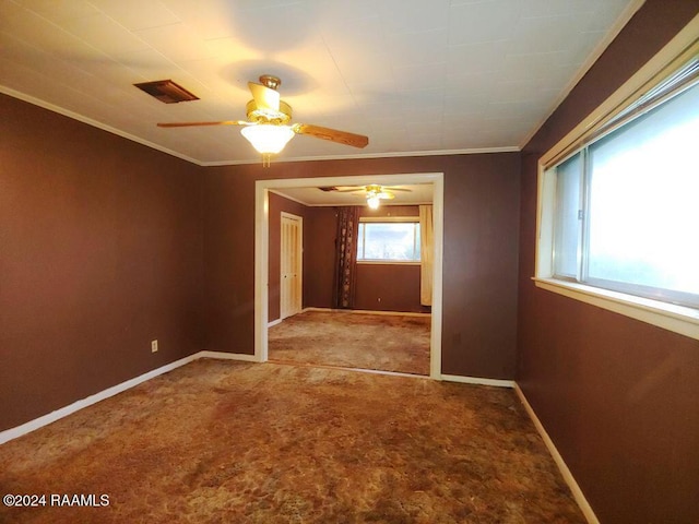 spare room with ornamental molding, carpet, visible vents, and baseboards