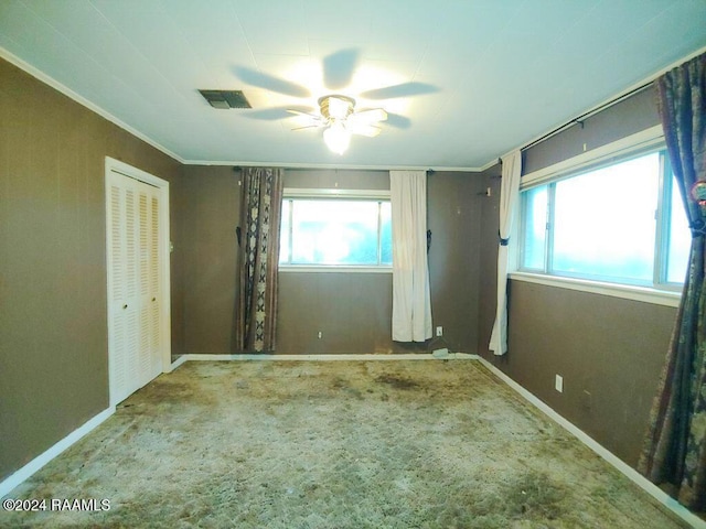 unfurnished bedroom with ceiling fan, ornamental molding, visible vents, and baseboards