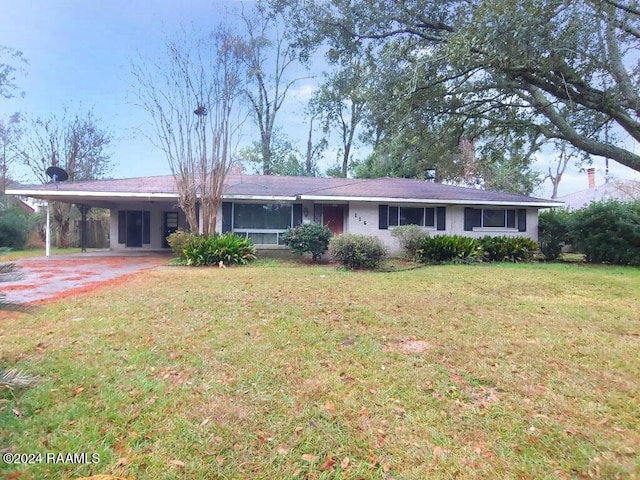 ranch-style house with driveway, a carport, and a front yard