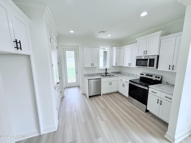 213 Berchman Oaks Dr, Lafayette, LA 70506 - kitchen featuring visible vents, a sink, crown molding, appliances with stainless steel finishes, and white cabinetry