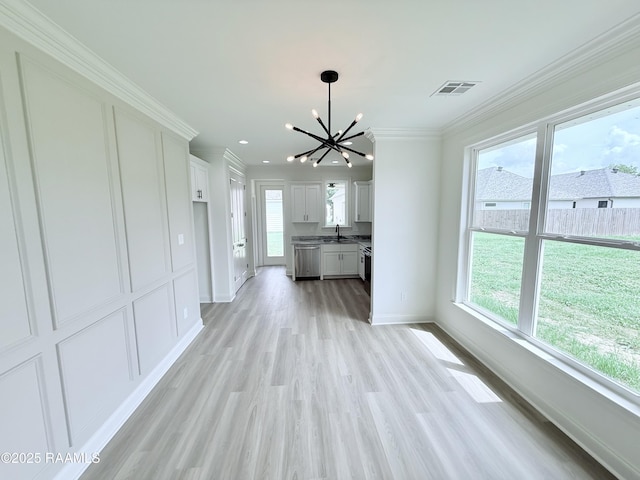 213 Berchman Oaks Dr, Lafayette, LA 70506 - unfurnished living room featuring light wood-style floors, crown molding, baseboards, and an inviting chandelier