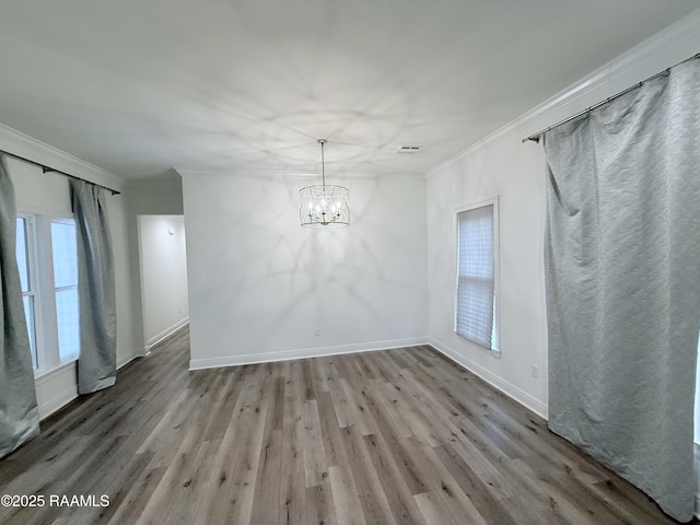 unfurnished room with light hardwood / wood-style flooring, ornamental molding, and an inviting chandelier