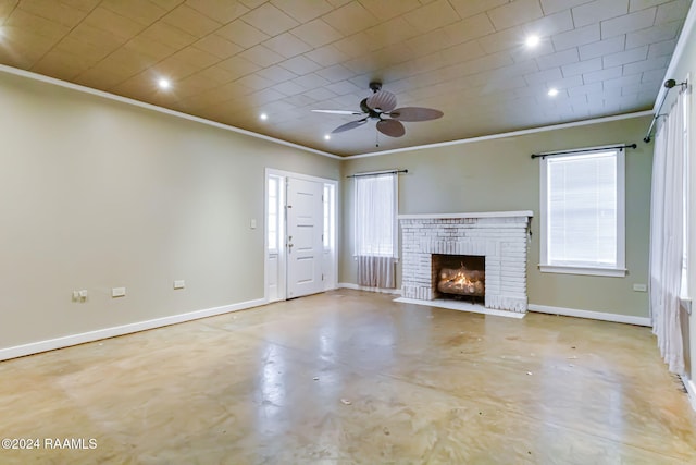 unfurnished living room with ceiling fan, a healthy amount of sunlight, ornamental molding, and a brick fireplace