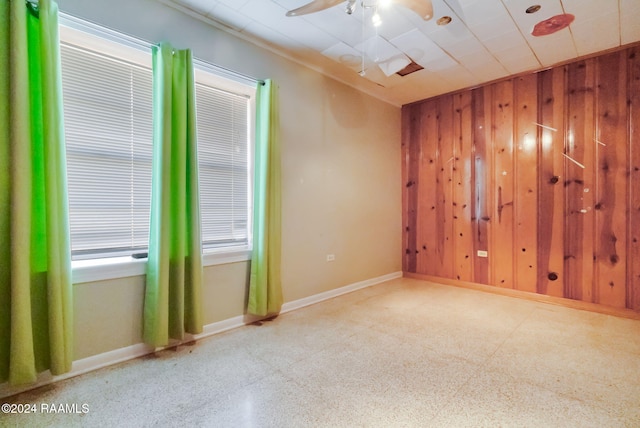 spare room with wooden walls and ceiling fan