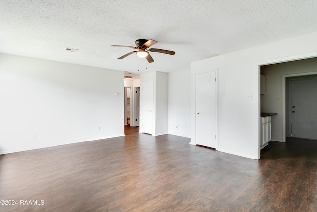 empty room with a textured ceiling, dark hardwood / wood-style floors, and ceiling fan