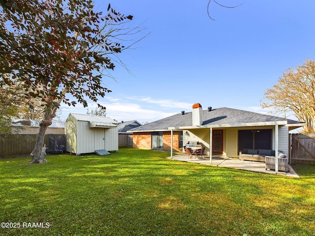 back of house with a lawn, a storage unit, and a patio