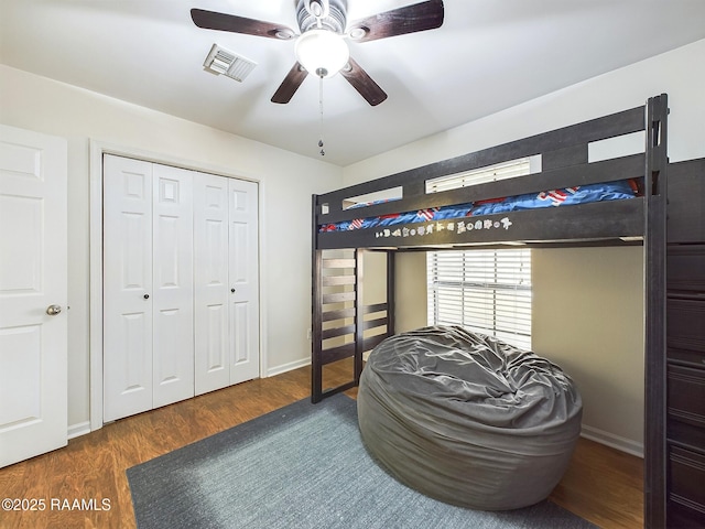 bedroom with ceiling fan, a closet, and dark wood-type flooring