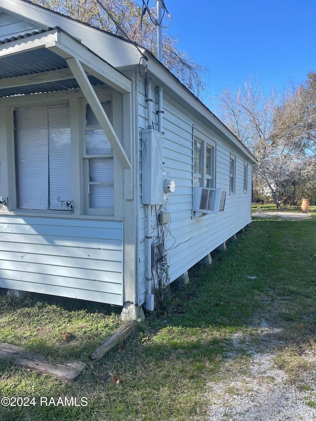 view of home's exterior with cooling unit and a lawn