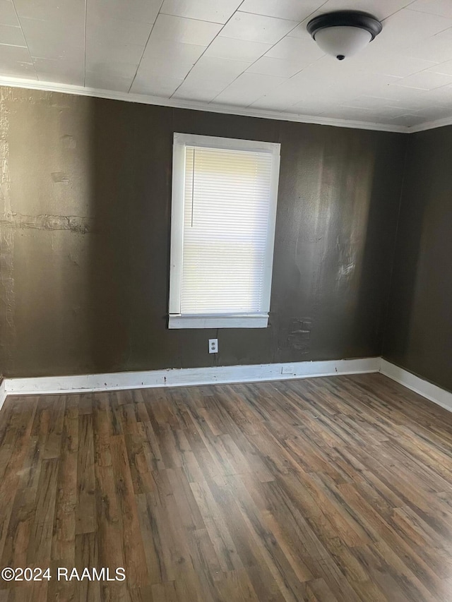 unfurnished room featuring wood-type flooring and ornamental molding