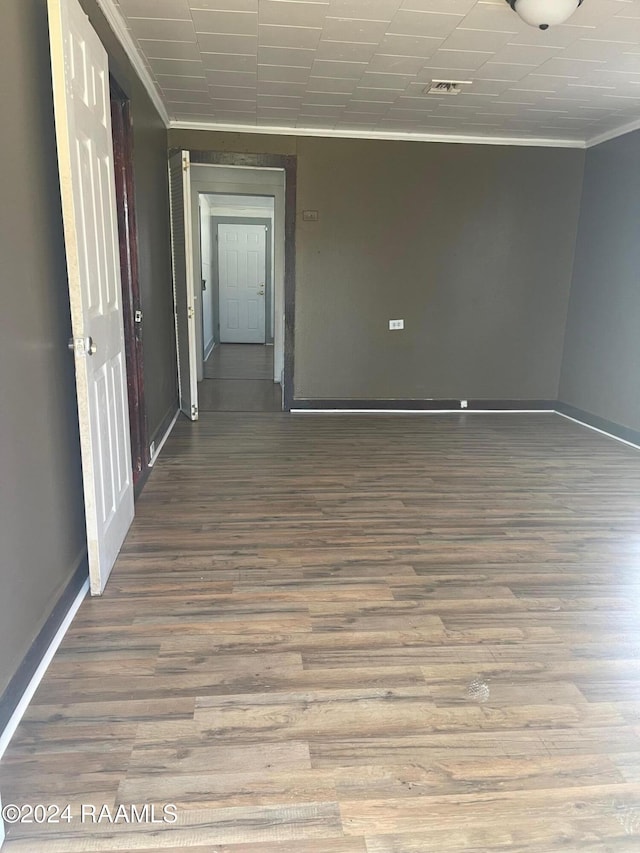 empty room featuring ornamental molding and hardwood / wood-style flooring