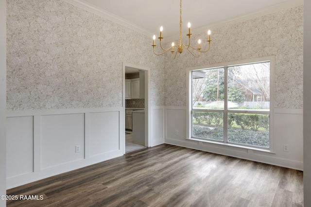 unfurnished dining area with plenty of natural light, dark hardwood / wood-style floors, crown molding, and a chandelier