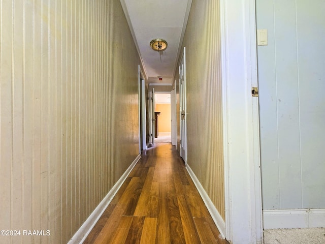 hallway featuring wooden walls and dark hardwood / wood-style floors