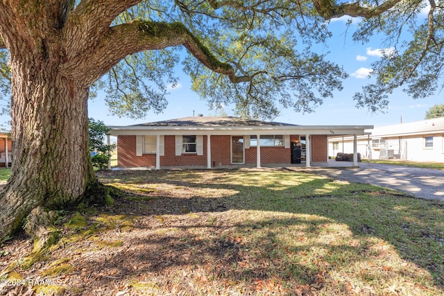 ranch-style home featuring a carport and a front lawn