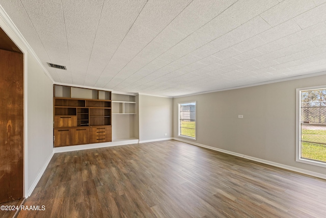 empty room with built in shelves and dark hardwood / wood-style flooring