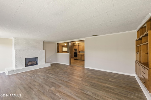 unfurnished living room with crown molding, dark hardwood / wood-style floors, and a brick fireplace