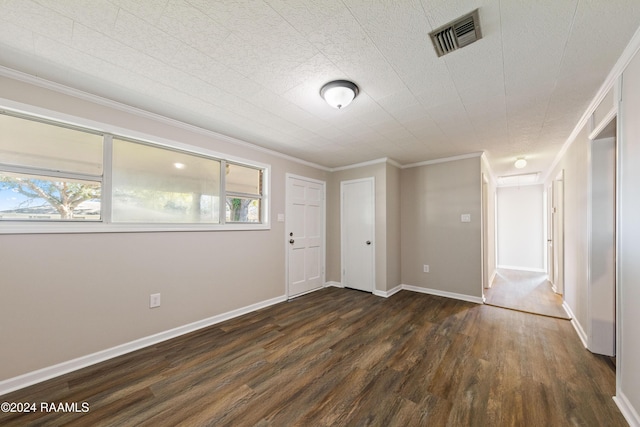 spare room featuring crown molding and dark wood-type flooring