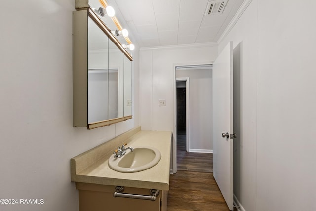 bathroom with hardwood / wood-style floors, vanity, and ornamental molding