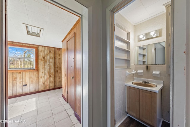 bathroom featuring wooden walls, built in features, vanity, and tile patterned flooring