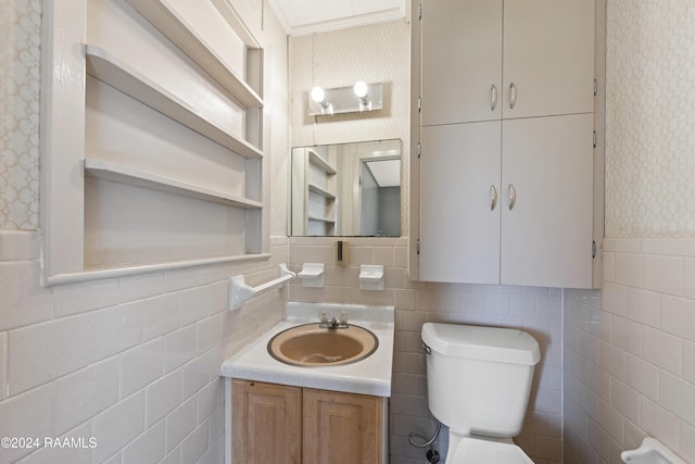 bathroom featuring vanity, toilet, tile walls, and ornamental molding