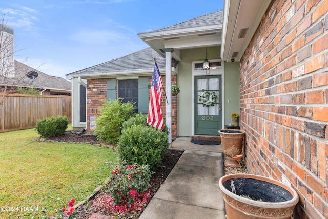 view of exterior entry featuring a yard