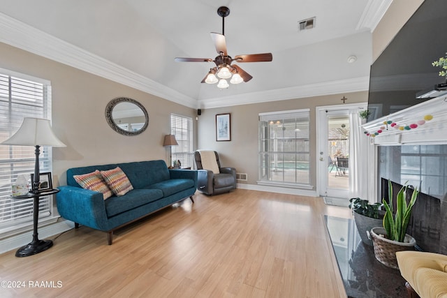 living room featuring ceiling fan, a high end fireplace, ornamental molding, and light wood-type flooring