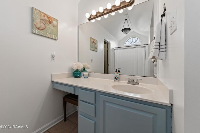 bathroom featuring tile patterned flooring, vanity, and lofted ceiling