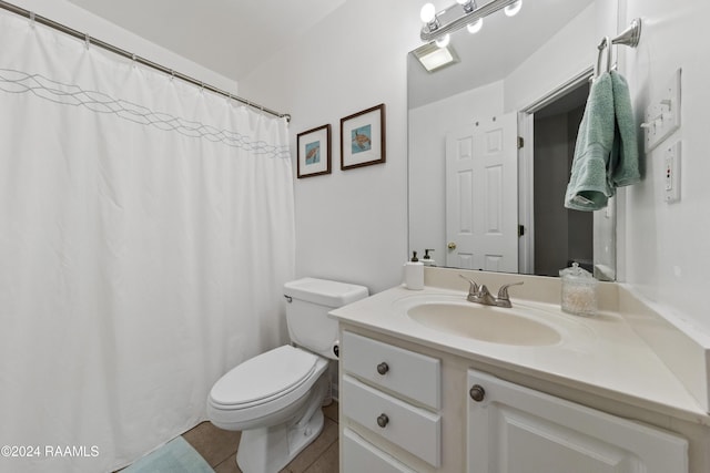 bathroom with tile patterned flooring, vanity, and toilet