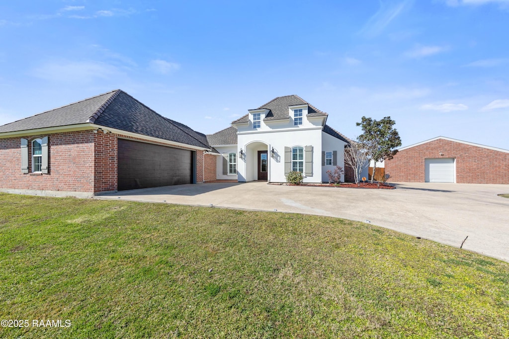 french provincial home with a front yard and a garage