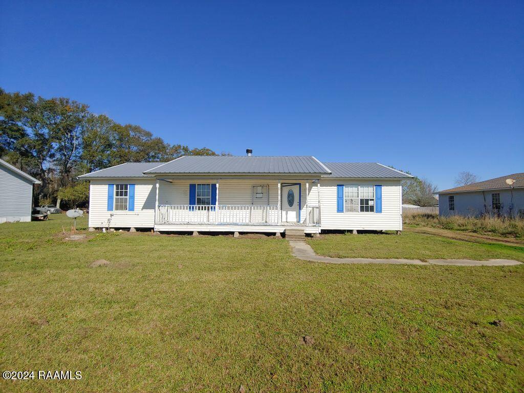 view of front of house with covered porch and a front yard