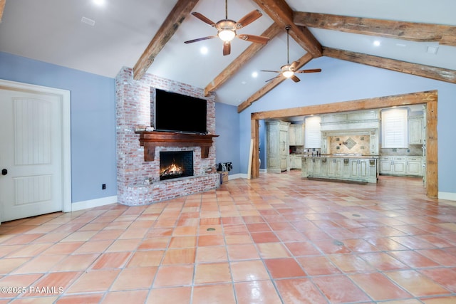 unfurnished living room featuring a fireplace, light tile patterned floors, high vaulted ceiling, and beamed ceiling