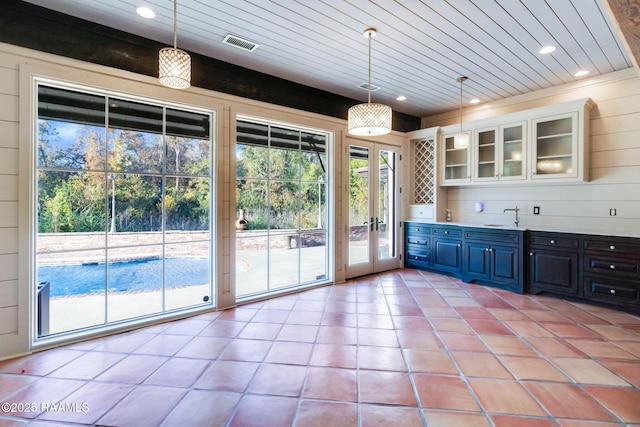 bar featuring pendant lighting, white cabinetry, blue cabinets, and french doors