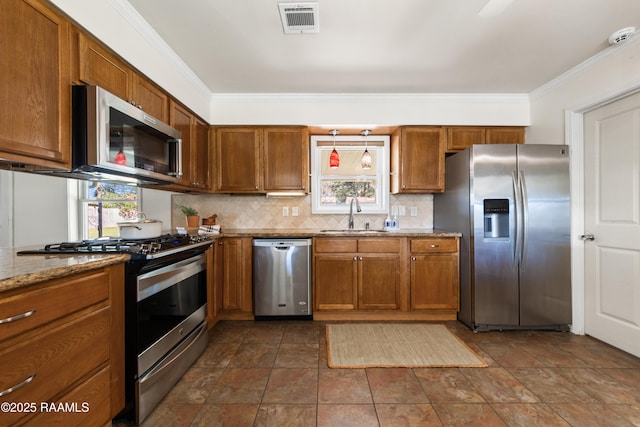 kitchen featuring backsplash, sink, ornamental molding, light stone counters, and stainless steel appliances