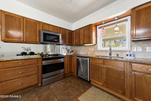 kitchen with light stone countertops, sink, stainless steel appliances, crown molding, and decorative light fixtures