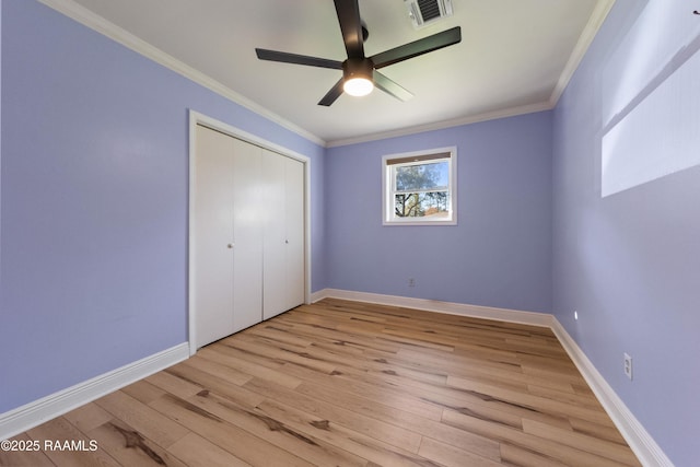 unfurnished bedroom with a closet, light hardwood / wood-style flooring, ceiling fan, and ornamental molding